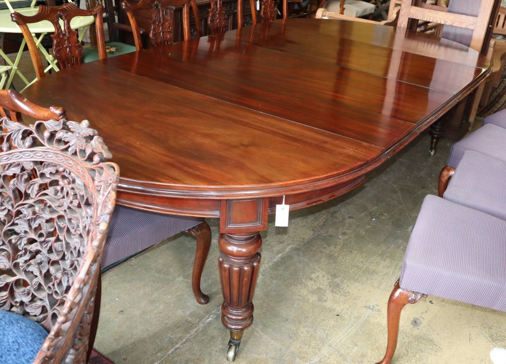 A Victorian mahogany extending dining table by Edwards and Roberts, together with an oak table leaf holder, 310cm extended (four spare